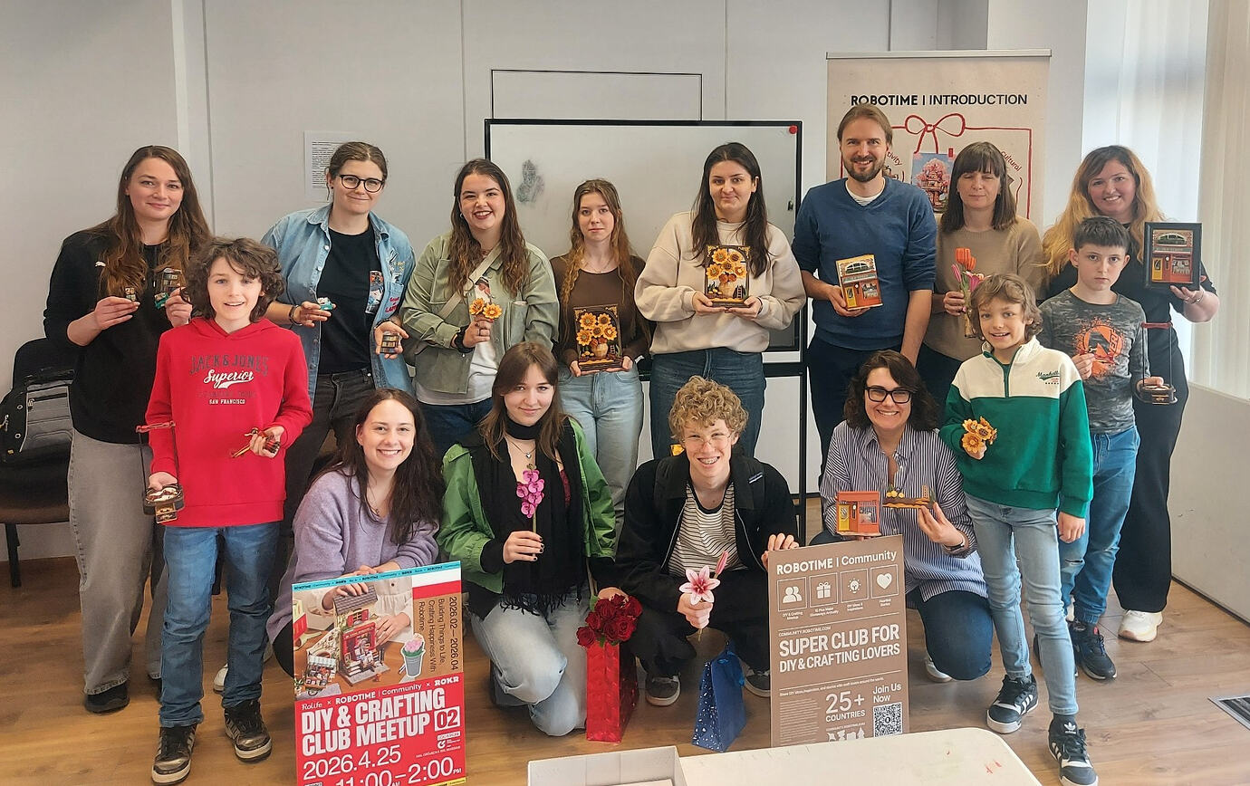 Adults and children at the Warsaw Robotime meetup hold completed and in-progress models for a group photo