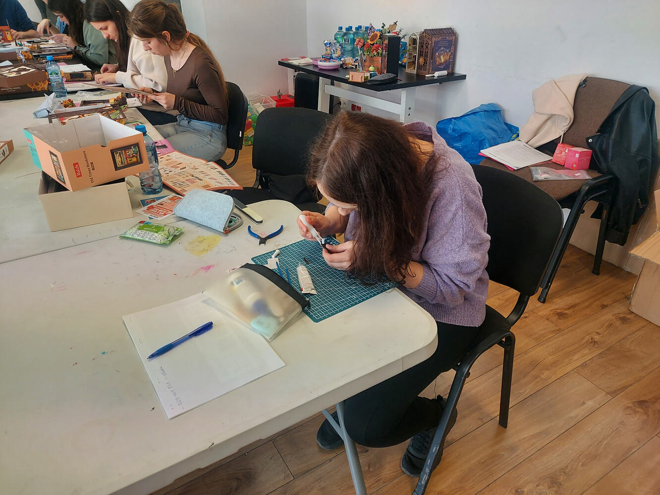 Deelnemers bouwen verder aan de tafel terwijl een model praktische hulp krijgt
