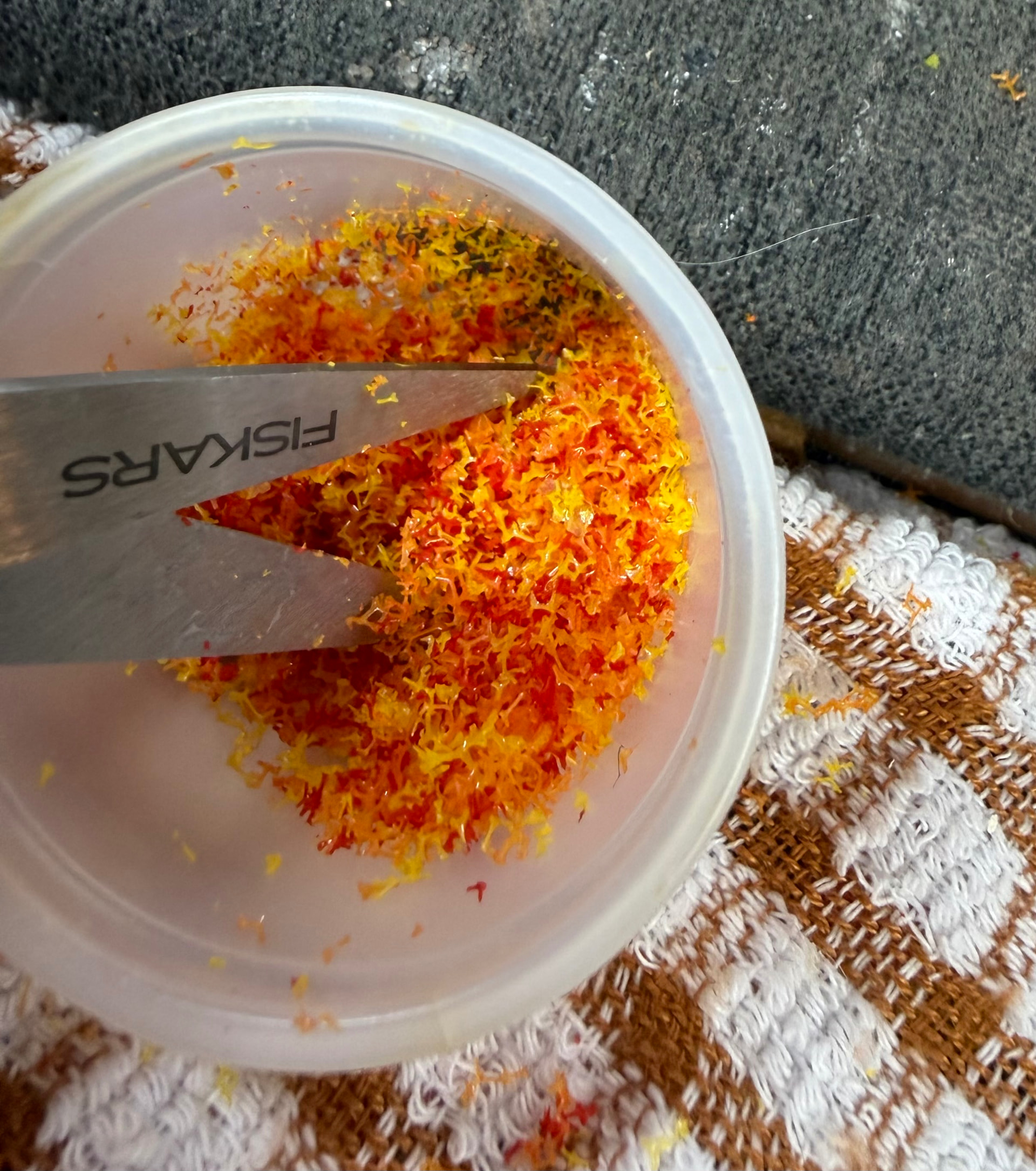 Orangefarbene, rote und gelbe Flockung, die in verschiedene Größen für Miniatur-Herbstblätter geschnitten wird